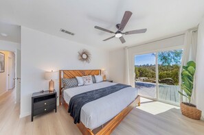 A bedroom with a bed, nightstands, a ceiling fan, and a view of a pool. - Oak-Studded Mountain Escape with Hot Tub & Game Room (Mariposa)