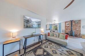 Una sala de estar con un sofá, una mesa de centro, un televisor y una chimenea.