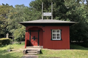 Een klein rood gebouw met een bord waarop 'Bahnhof STELLDICHEIN' staat en een kruisbeeld op de deur.