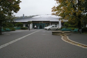 A building with a dome roof, a paved entrance area, and green seating. - Holiday apartment with 2 bedrooms (Bad Tabarz)