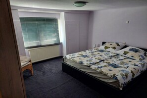 A bedroom with a single bed, a radiator, a window with blinds, and a door. - Holiday apartment with 2 bedrooms (Bad Tabarz)
