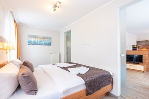 Ein Hotelzimmer mit Bett, Nachttisch, Lampe und einem Bild an der Wand.
