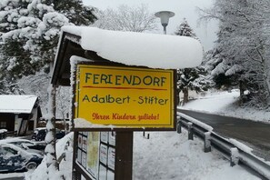 A sign with the text 'FERIENDORF Adalbert-Stifter' and a welcoming message to children. - Adalbert Stifter Holiday Village (Hauzenberg)