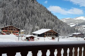 A snow-covered mountain village with wooden buildings and a ski resort.