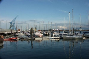 A marina with various boats docked, a crane structure on the left, and a clear sky. - Holiday apartment with 2 bedrooms (Cuxhaven-Duhnen)