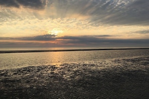 A coastal landscape with a calm sea and a cloudy sky. - Holiday apartment in Husum with swimming pool (Husum)