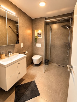A modern bathroom with a vanity, toilet, and walk-in shower. - Modern Apartment with Stunning Mountain Views @ Sunrise Pfronten (Pfronten)