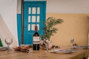 A table set with a bottle of wine, a glass, and a potted plant. - Villa in Pitsidia with swimming pool (Pitsidia)