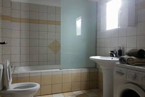 A bathroom with a toilet, sink, and washing machine. - Villa in Pitsidia with swimming pool (Pitsidia)