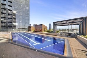 A rooftop swimming pool with a clear view of the city skyline. - High-Rise 1-Bed Apartment in Docklands (Docklands)