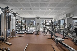 Un gimnasio moderno con cintas de correr, elípticas y equipo de pesas.