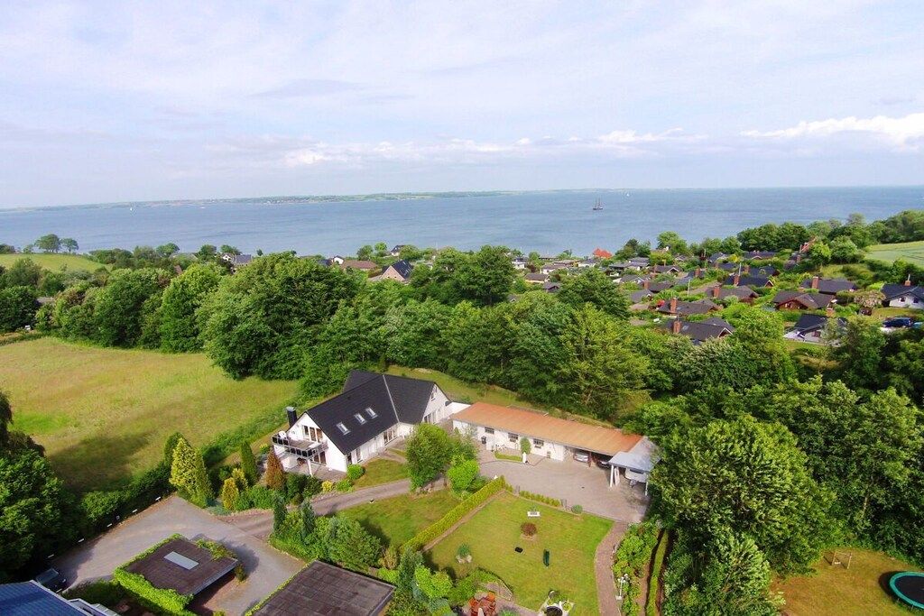 Een woonwijk met huizen, een groot wateroppervlak en een heldere lucht.