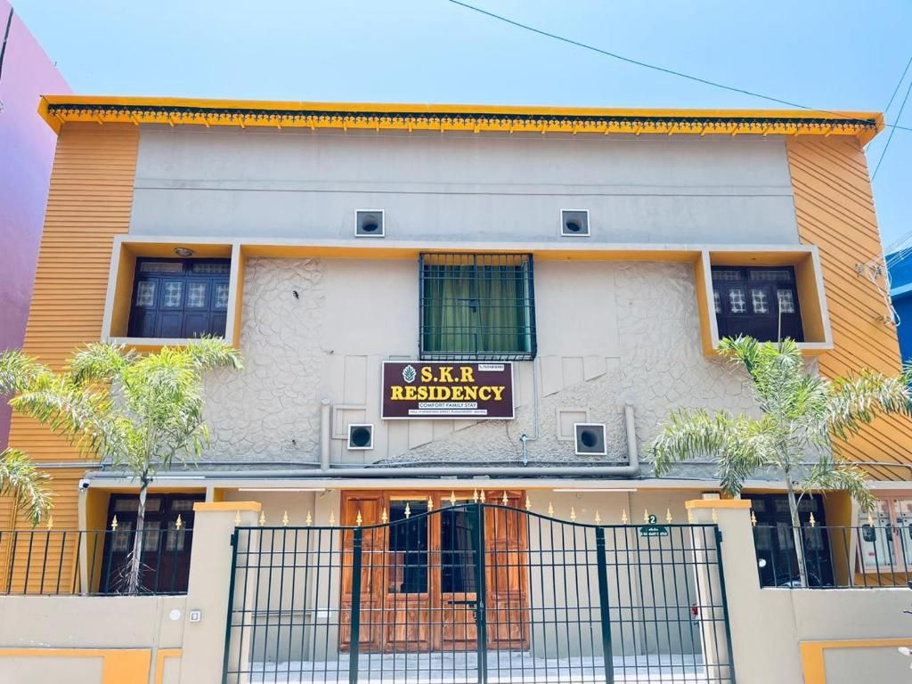 A building with a sign reading 'S.K.R. RESIDENCY' and a gated entrance.