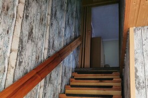A wooden staircase with a handrail leading to an open doorway. - Mary holiday apartment (Karlsburg)