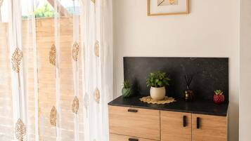 A modern kitchen with a black countertop, wooden cabinets, and a potted plant.
