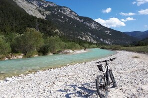 A mountain landscape with a clear river, a bicycle, and rocky terrain. - Apartment in Krün with swimming pool (Krün)