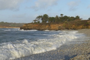 A rocky coastline with waves crashing onto the shore, a cliff with trees, and a clear sky. - Lambezen-maison aux volets bleus (Camaret sur mer)