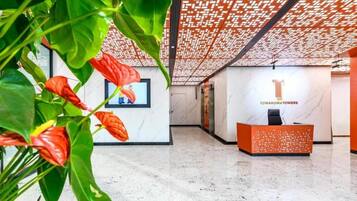 A reception area with a marble floor, a reception desk, and a wall-mounted screen.