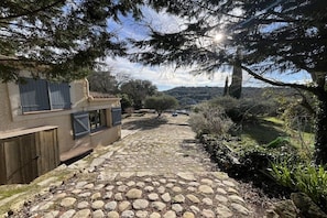 A stone pathway leading to a house with a view of the countryside. - Holiday home with 3 bedrooms (Cabrials (Aumelas))
