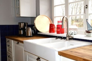 A kitchen with a white sink, wooden countertop, and cabinets. - Holiday home Mechelsdorf (Mechelsdorf)