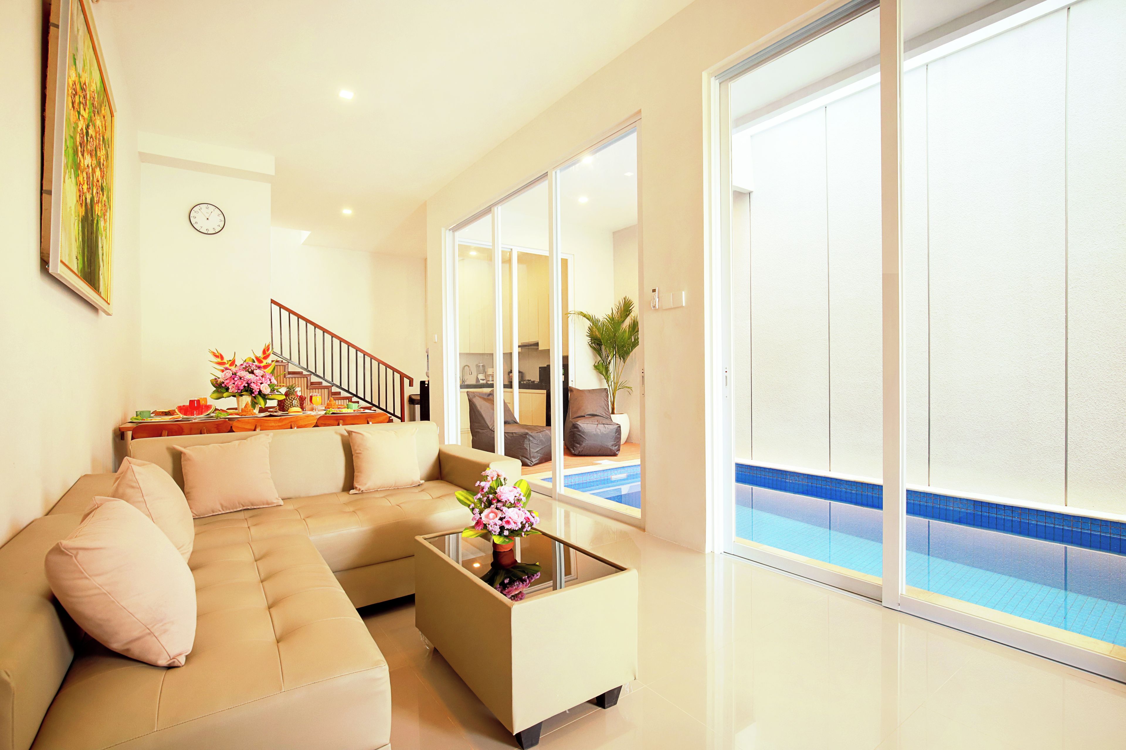 Una sala de estar moderna con un sofá, una mesa de centro y vistas a una piscina.