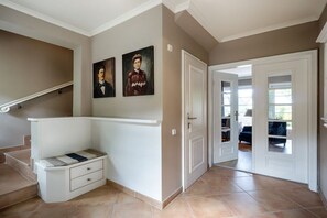 A hallway with a staircase, a bench, and a door leading to a room. - Holiday home in Sylt with 2 bedrooms (Westerland)