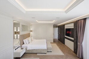 A modern hotel bedroom with a large bed, bedside tables, a mirror, and a television screen displaying 'NETFLIX'. - 3br Luxurious Villa Gold Chariott (Bangtao)