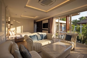 A spacious hotel room with a large bed, multiple seating areas, and a balcony with a view of the outdoors. - 3br Luxurious Villa Gold Chariott (Bangtao)