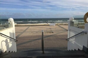 Vistes des d'un balcó amb vista al mar, amb barana i una finestra rodona.