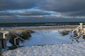 A snow-covered beach with a wooden staircase leading down to the water. - Holiday apartment Haus Meeresblick 319637 (Kühlungsborn - West)