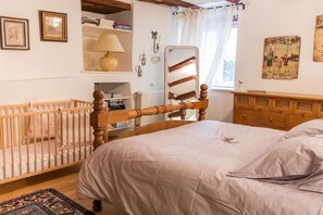 A bedroom with a wooden bed, a crib, a dresser, and a radiator. - Holiday apartment with 2 bedrooms (Ribeauville zwischen  Strasbourg und Colmar)