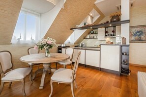 Une cuisine moderne dotée d’un îlot central, de meubles blancs et offrant une vue sur l’extérieur grâce à une grande fenêtre.