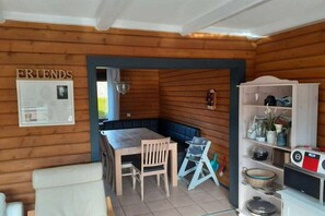 A wooden interior with a table and chairs, a shelf with kitchenware, and a sign that reads 'FRIENDS'. - Lakeside with valley view, upper floor (Arrach)