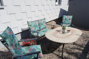 An outdoor seating area with a round table and four chairs with floral upholstery. - Holiday apartment with 2 bedrooms (Weißenstadt!)