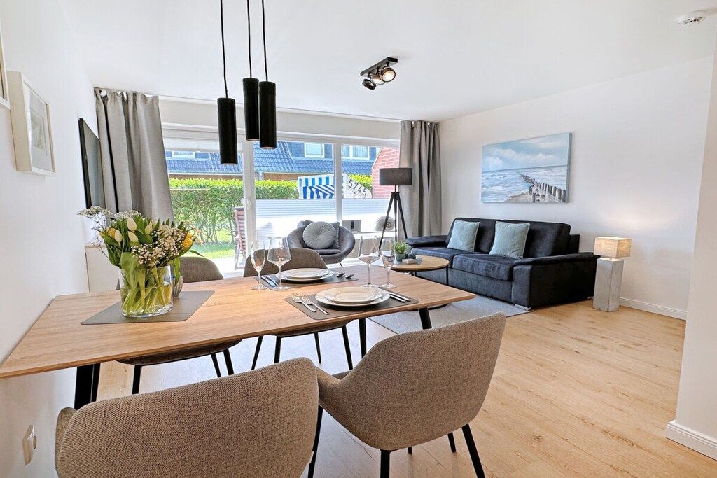 A modern living room with a dining area, a sofa set, and a view of the outside.