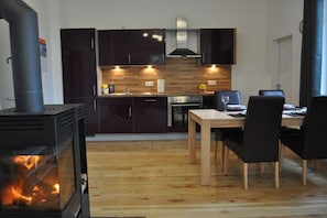 A modern kitchen with dark cabinets, a wooden countertop, and a built-in oven. - Holiday home in Dunum with sauna (Dunum)
