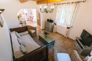 Un salon confortable avec un canapé, un téléviseur et une table basse en bois.