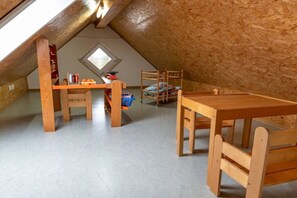 A loft bedroom with a sloped ceiling, a bunk bed, a desk, and a window. - Holiday apartment with 1 bedroom (Tettnang)