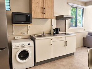 A compact kitchenette with a microwave, coffee maker, and a built-in washing machine. - Patio & tropical garden, BBQ, 5 minutes from the beach (Rivière-Pilote)