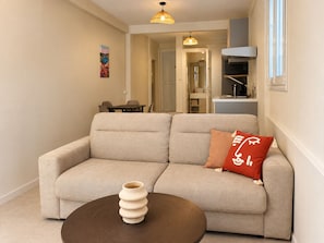 A living room with a sofa, a coffee table, and a painting on the wall. - Patio & tropical garden, BBQ, 5 minutes from the beach (Rivière-Pilote)