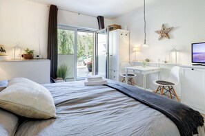 Een moderne slaapkamer met een bed, een bureau en een televisie.