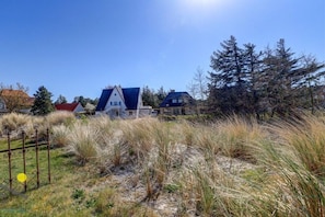 A residential area with houses, a clear sky, and a fence. - Ordinger Dün Holiday Apartment 2 (St. Peter-Ording)