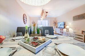 Een eethoek met een gedekte tafel, een televisie en een decoratief wandobject.