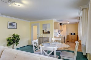 A compact living space with a dining area, kitchenette, and a small seating area. - Villa "Helma" Apartment 2 (Seebad Heringsdorf)