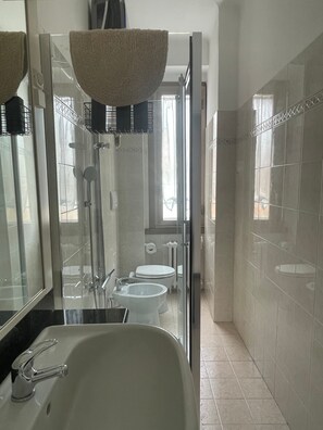 Un bagno con una vasca, un water e una doccia.