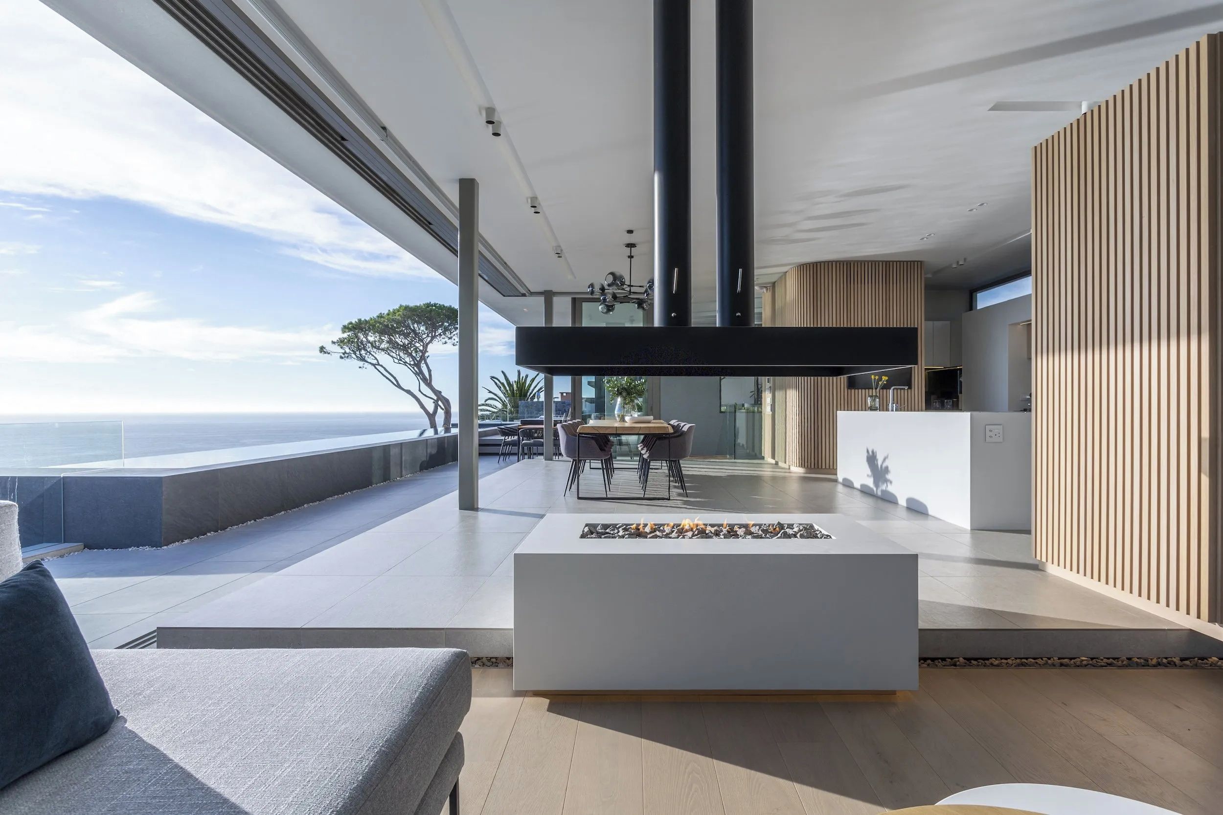 Un intérieur moderne comprenant un coin repas, une cuisine et une vue sur la mer.