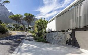 A modern building with a stone wall and a garage door. - Epic Villa by Golden Sands Escape (Cape Town)