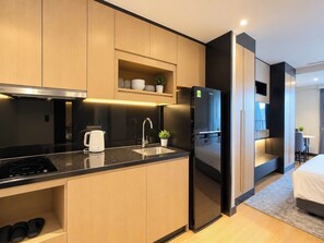A modern kitchen with a built-in stove, a refrigerator, and a sink. - Soliel Hotel Da Nang (An Hai)