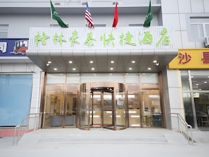 A hotel entrance with a glass door, a revolving door, and a sign with Chinese characters. - Greentree Inn Beijing Tongzhou District Xuxinzhuang Subway Station Express Hotel (Tongzhou)
