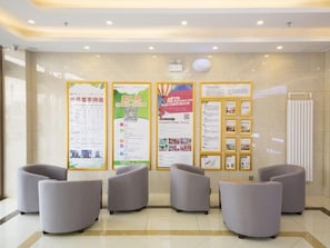 A reception area with a clean, modern design, featuring a reception desk, several seating areas, and informational posters on the wall. - Greentree Inn Beijing Tongzhou District Xuxinzhuang Subway Station Express Hotel (Tongzhou)